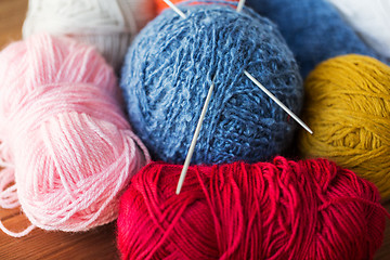 Image showing knitting needles and balls of yarn on wood