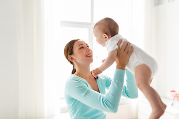 Image showing happy young mother with little baby at home