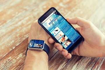 Image showing hands with news web page on smart phone and watch