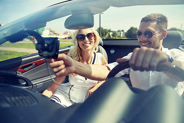 Image showing happy couple using gps navigator in cabriolet car