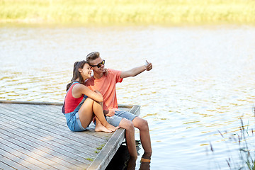 Image showing happy teenage couple taking selfie on smartphone