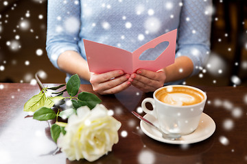 Image showing woman with coffee and flower reading greeting card