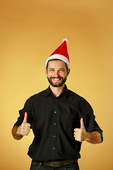 Image showing Smiling christmas man wearing a santa hat