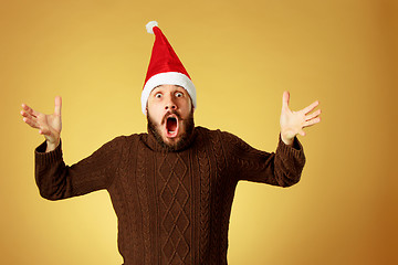 Image showing Surprised christmas man wearing a santa hat