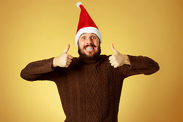 Image showing Smiling christmas man wearing a santa hat