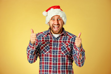 Image showing Smiling christmas man wearing a santa hat
