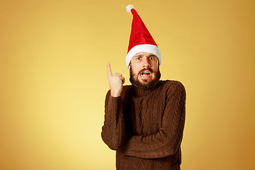 Image showing Surprised christmas man wearing a santa hat