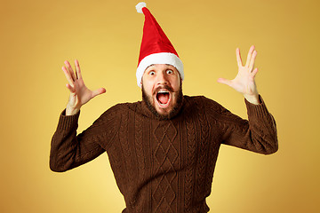 Image showing Surprised christmas man wearing a santa hat