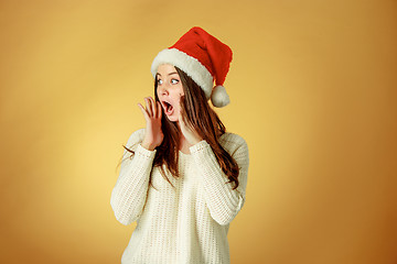 Image showing Surprised christmas girl wearing a santa hat