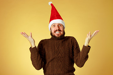 Image showing Surprised christmas man wearing a santa hat