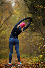 Image showing Young blonde on stretching exercises in autumn park