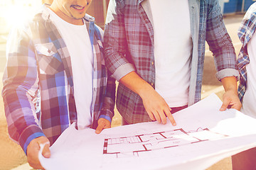 Image showing close up of smiling builders with blueprint