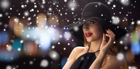 Image showing beautiful woman in black hat over night lights