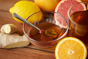 Image showing tea with honey, lemon and ginger on wood