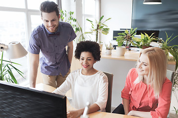 Image showing happy creative team with computer in office