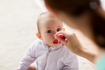 Image showing mother with spoon feeding little baby at home