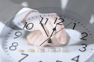 Image showing clock over businessman counting euro coins