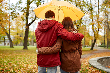 Image showing happy couple with umbrella walking in autumn park