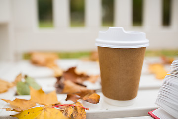 Image showing coffee drink in paper cup on bench at autumn park