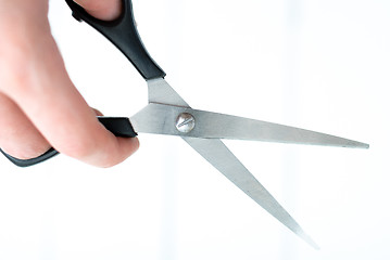 Image showing the hand holds the scissors for thinning out on an isolated white background