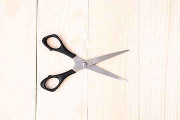 Image showing Scissors on wooden background