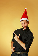 Image showing Smiling christmas man wearing a santa hat