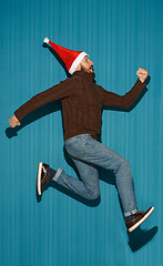 Image showing The running christmas man wearing a santa hat