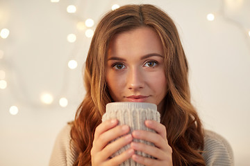 Image showing happy woman with cup of tea or coffee at home