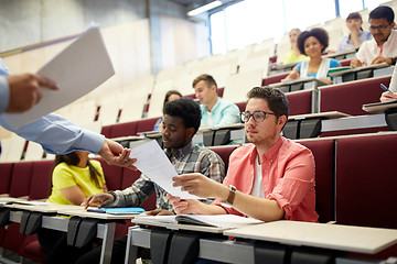 Image showing teacher giving tests to students at lecture
