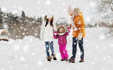 Image showing happy family in winter clothes walking outdoors