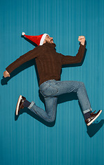 Image showing The running christmas man wearing a santa hat