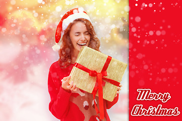 Image showing Girl dressed in santa hat with a Christmas gift