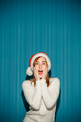 Image showing Surprised christmas girl wearing a santa hat