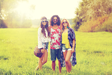Image showing smiling young hippie friends on green field