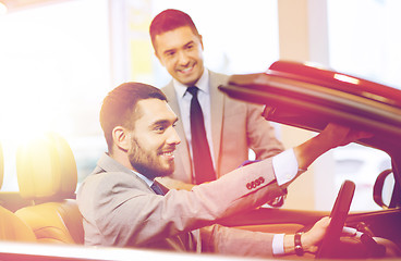 Image showing happy man with car dealer in auto show or salon