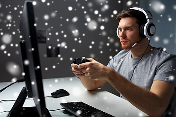 Image showing man in headset playing computer video game at home