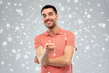 Image showing man pointing finger to you over snow background