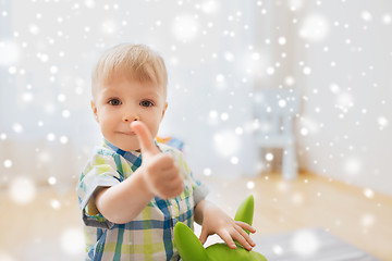 Image showing happy baby boy playing with toy showing thumbs up