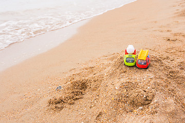 Image showing Two toy cars left the children on the beach