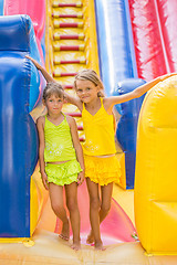 Image showing Two children stand at the entrance of a large inflatable trampoline