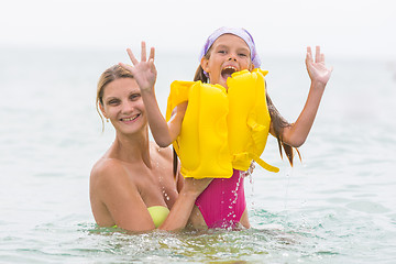 Image showing She pulled out of the water his seven-year daughter in the swimming vest