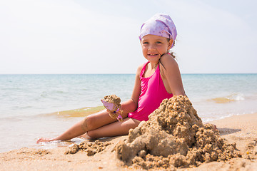 Image showing The baby digs a shovel sand sitting on the beach