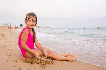 Image showing Five-year girl sitting on the beach seaside