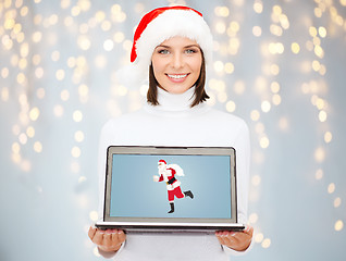 Image showing woman holding laptop with santa claus on screen