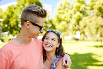 Image showing happy teenage couple looking at each other in park