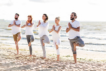 Image showing people making yoga in tree pose on summer beach