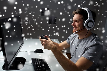 Image showing man in headset playing computer video game at home