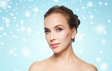 Image showing beautiful woman face over blue background and snow