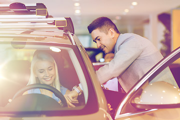 Image showing happy woman with car dealer in auto show or salon