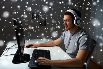 Image showing man in headset playing computer video game at home